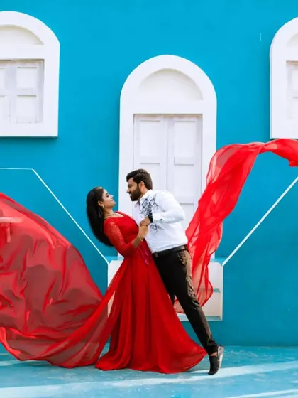 A classic romantic pose. The vibrant red of her gown and the crisp white of his shirt make for a striking and passionate pre-wedding photograph.