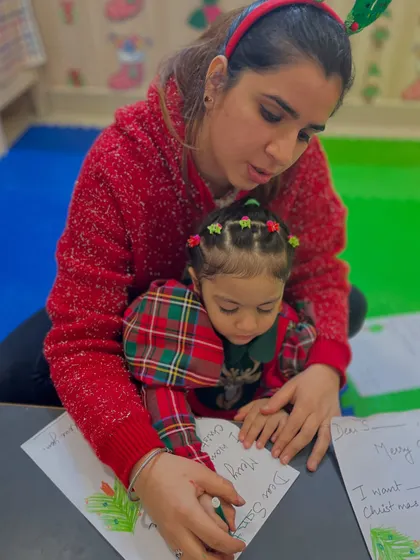 A mother and daughter write a letter to Santa together, a magical activity that also practices pre-writing skills.