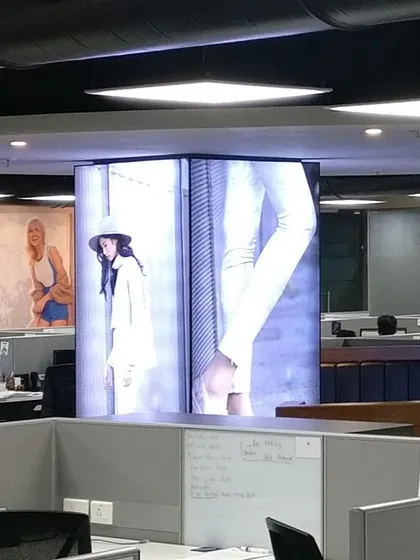 The open-plan office for Skechers features a central column with an integrated digital display. This serves as a dynamic focal point for branding and internal communication, aligning the workspace with the company's culture.