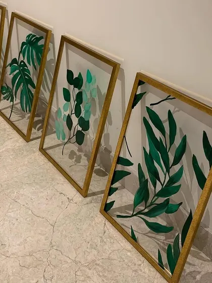 I love experimenting with different materials. Here, I painted a series of botanical leaves on acrylic sheets with gold frames, creating a floating effect that is modern and chic.