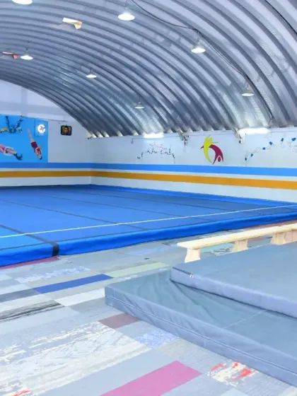 Welcome to our home. A glimpse of our clean, spacious, and well-equipped training facility, featuring a full-size floor, balance beams, and safety mats for our gymnasts.