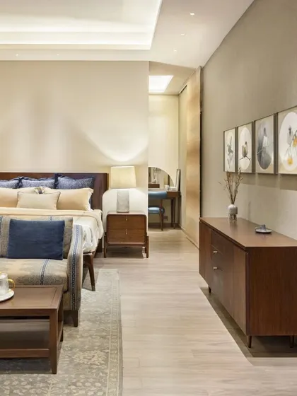 The master bedroom in the Max128 apartment is a study in tranquility. We used a palette of soft beiges and regal blues, with curated art and warm wood furniture to create a serene and personal sanctuary.