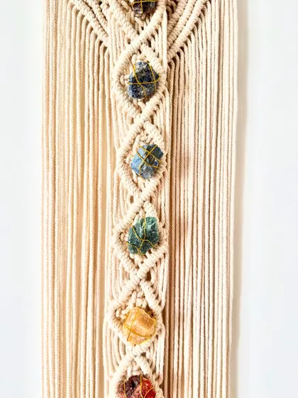 A close-up of the 7 chakra stones, each carefully wrapped and integrated into the macrame design. This piece was made for a client on her spiritual journey.