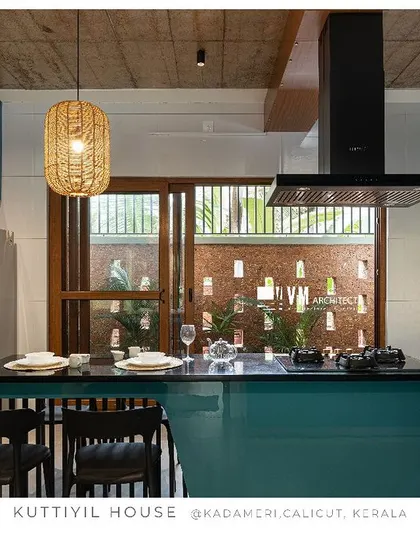 A duplicate of image 111, showcasing the functional and stylish kitchen design at Kuttiyil House, with its bold color and connection to the outdoors.