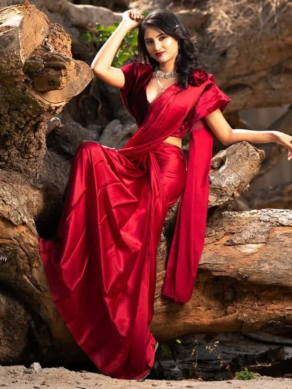 A stunning portrait in a vibrant red satin saree. We used a large, weathered tree trunk as a natural, rustic backdrop to contrast with the elegance of the outfit.