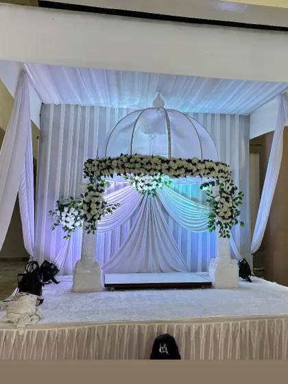 A simple and elegant all-white theme for a Ganpati mandap. This clean look uses white drapes, white flowers, and soft lighting to create a peaceful and serene atmosphere.