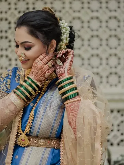 A close-up of the bride getting ready, highlighting her henna and traditional green bangles.