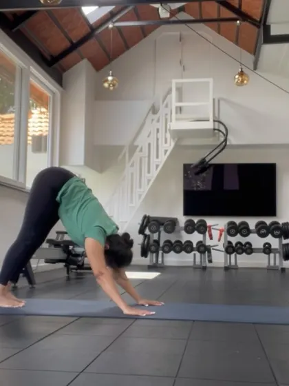 A student practices Adho Mukha Svanasana (Downward-Facing Dog) in our beautiful studio space. The natural light and clean environment create a peaceful atmosphere for focused practice.