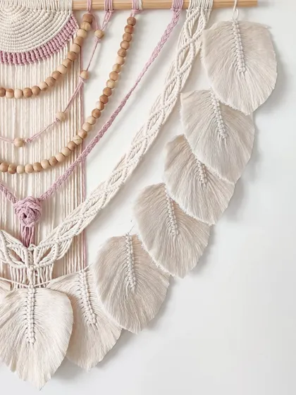 A detailed view of the cascading macrame leaves on this beautiful, beaded wall hanging.
