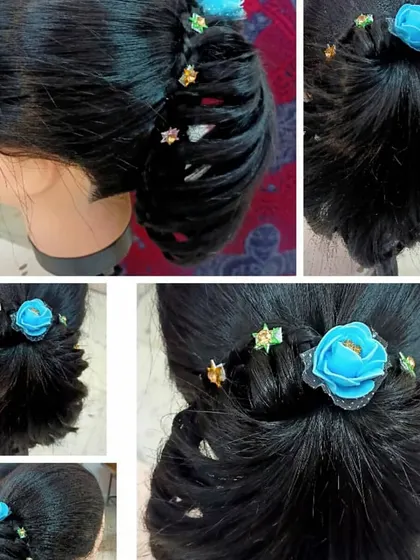 Another example of student practice on a mannequin. This stylish bun incorporates a side braid and is adorned with a blue flower, showing how students learn to integrate accessories into their hairstyles.