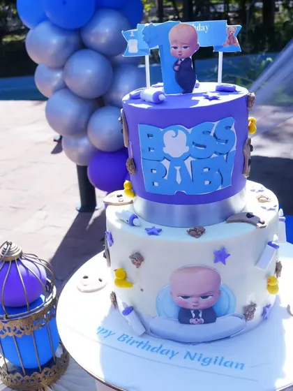 A two-tiered Boss Baby themed cake, perfectly matching the party's blue and purple decor.