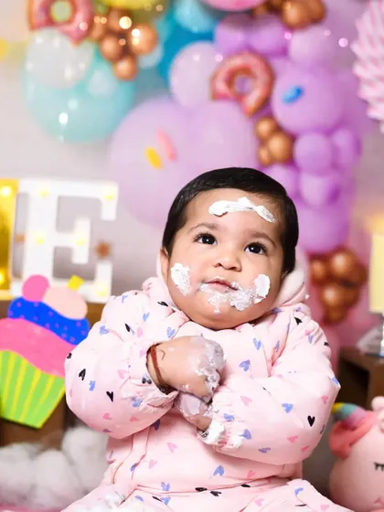 A quiet moment of contemplation amidst the cake chaos. Even the thoughtful expressions are priceless memories from a first birthday shoot.