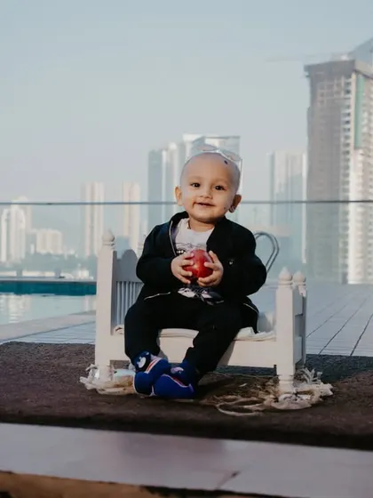 A wide shot showing the full poolside setup with the Mumbai skyline in the background, adding a unique urban feel to this kids' photoshoot.
