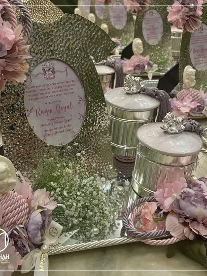 Another perspective of the 'Raya Goyal' announcement hamper, focusing on the intricate details. The silver tray holds the personalized frame, keepsake jars, and is accented with pearls and silk flowers.