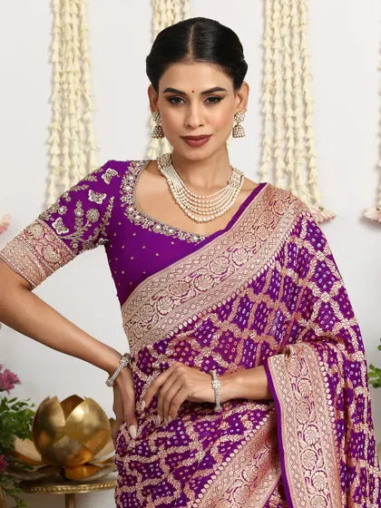 A close-up of the royal purple Bandhani saree, paired with an embroidered blouse and a pearl necklace.