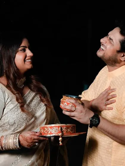 A candid moment of laughter and playfulness during a Karwa Chauth celebration. This image shows the genuine, happy connection between the couple as they share a lighthearted moment after the fast.