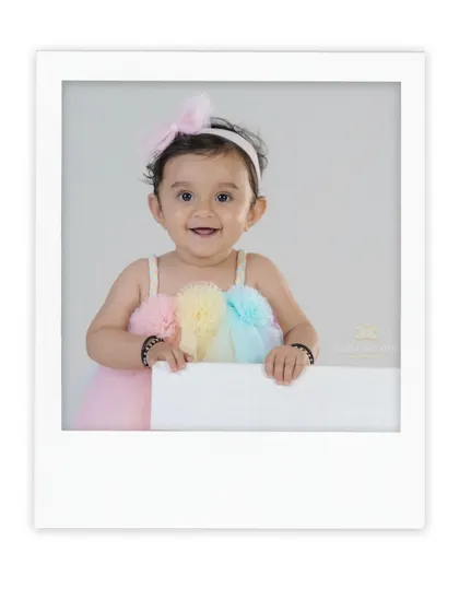 A happy baby girl in a lovely pastel dress. The simple white frame gives this studio portrait a clean and modern feel.