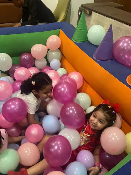 The kids having a blast in an inflatable ball pit filled with pastel-colored balls, perfectly matching the unicorn party theme. Safe and fun entertainment for the little ones.