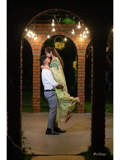 A playful and romantic lift under an archway of lights. This shot is full of joy and captures the magic of a night-time pre-wedding session.