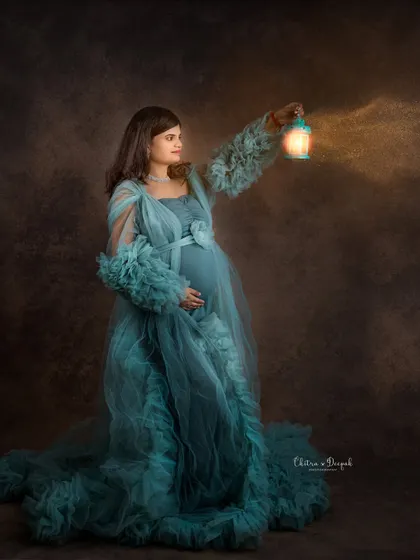 Lighting the way. This artistic shot uses a lantern prop to create a warm glow, adding a touch of mystery and magic to this maternity portrait.
