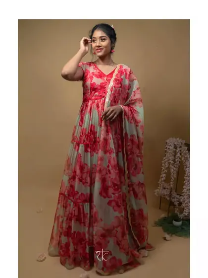 A full view of the flowing red and mint floral organza gown. The tiered skirt and matching dupatta create a dreamy, romantic silhouette perfect for a reception.