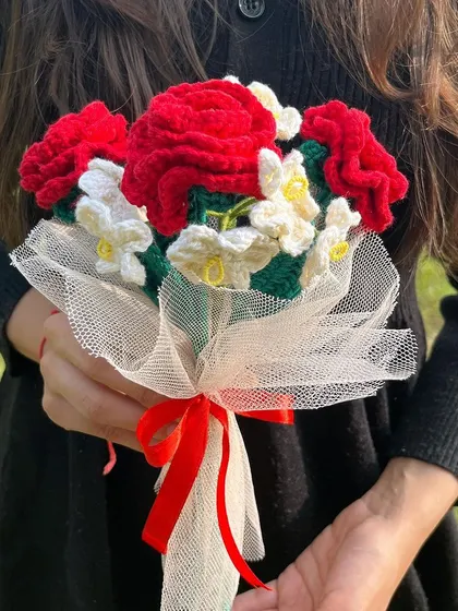 A full view of the red rose and white flower bouquet, showing the delicate netting and red ribbon that completes the look.