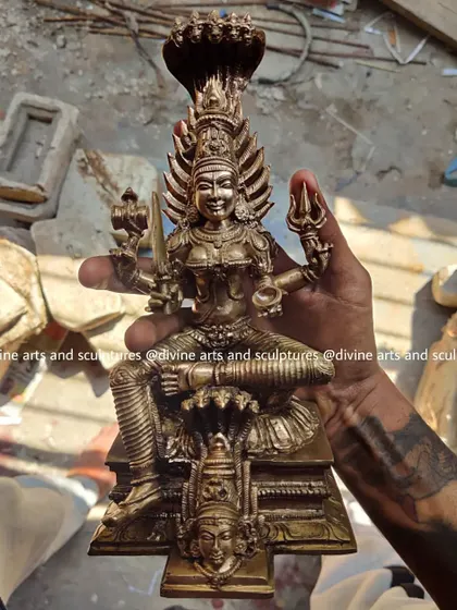 One of our artisans holding a newly completed 10-inch Panchaloha sculpture of Karumariamman. This shows the scale of the piece and the pride we take in holding the finished, blessed form in our hands.