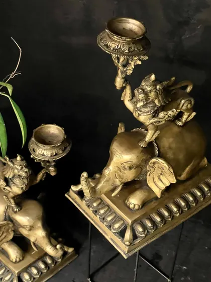 An overhead view of the brass candle stands, showing the beautiful symmetry of the pair. These vintage Tibetan-style pieces are perfect for adding a touch of Asian elegance and warm light.
