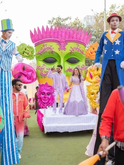 Let the festivities begin. The couple makes their entrance flanked by stilt walkers and jugglers, creating a full-blown carnival parade.