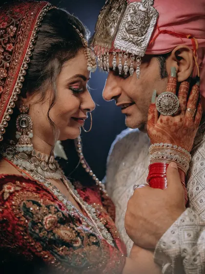 A wedding portrait that captures the soul of the relationship. The gentle touch, the loving gaze, and the rich details of the traditional wedding attire come together to create a timeless image of love and commitment.