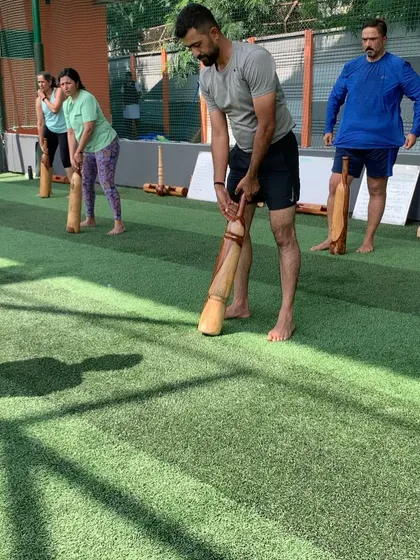 A group of golfers engages in a barefoot training session. This practice helps improve grounding and stability, which are crucial for a consistent golf swing.
