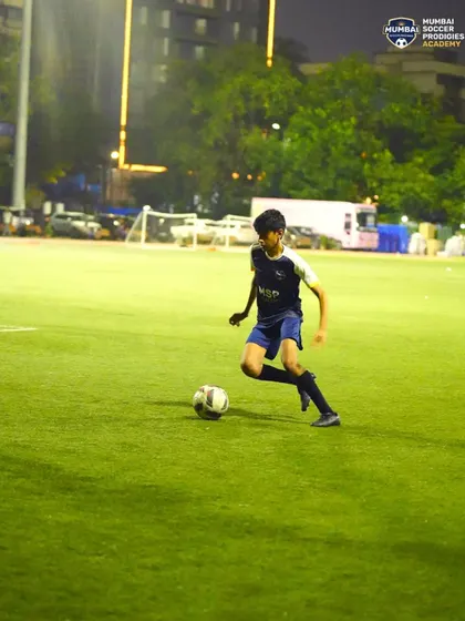 Driving forward with purpose, a player advances the ball up the field during a practice game.