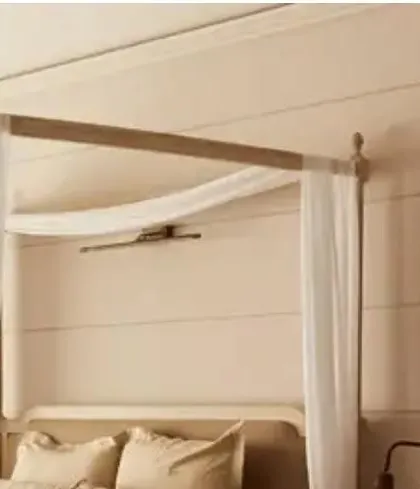Another angle of the Goa villa bedroom, highlighting the clean lines of the wall paneling behind the bed, which complements the classic form of the four-poster frame.