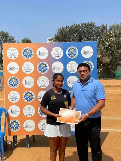 An official presents Eshita with her trophy at the SS U-16 Bengaluru tournament. These formal recognitions mark important milestones.