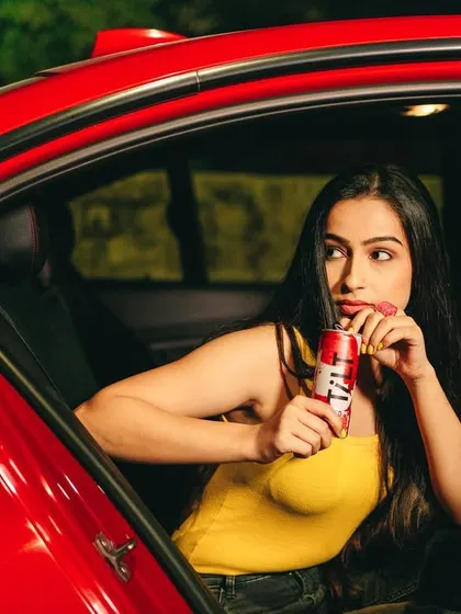 A fun, candid-style shot for Tilt wine, showing a model enjoying the drink in the back of a car. This image captures a moment of spontaneous fun, perfect for a brand targeting a young, adventurous audience.