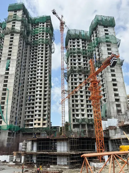 Construction progress on a large-scale residential township, showing the concrete shells of the towers rising against the skyline.