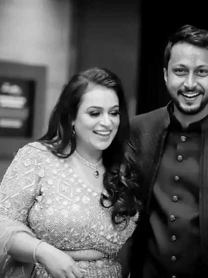 A candid black and white shot of the couple sharing a laugh. This photo captures the genuine fun and happiness of their engagement celebration.