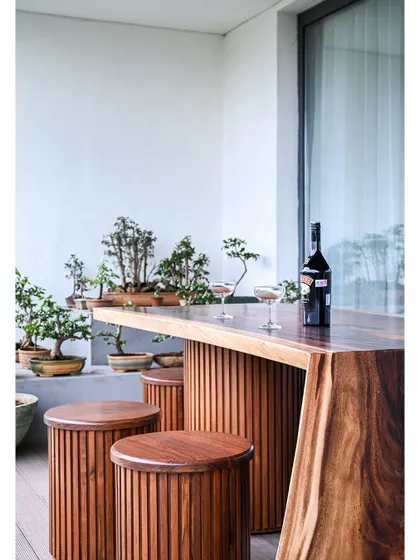 This custom outdoor furniture piece is perfect for enjoying a drink while overlooking the city and the client's impressive bonsai collection.