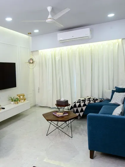 A dream living room with a bold blue sofa, a floating white TV unit, and clean white walls, creating a fresh and modern aesthetic.