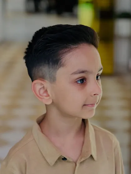 This side view shows the neat fade and clean lines of his new haircut, a style that's both smart and easy to manage.