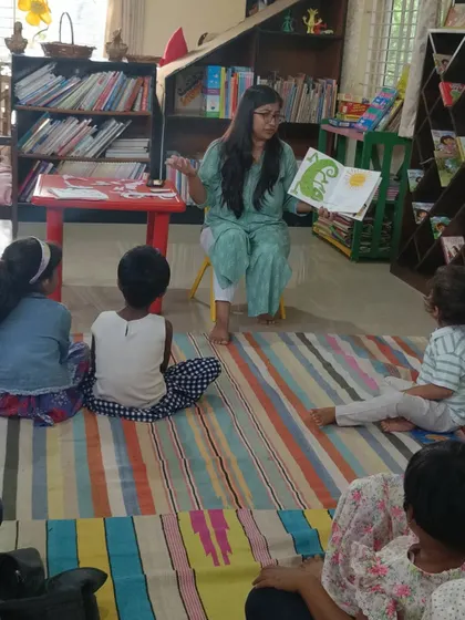 A clear shot of the children listening to the story, with the colorful mat adding to the cheerful ambiance.