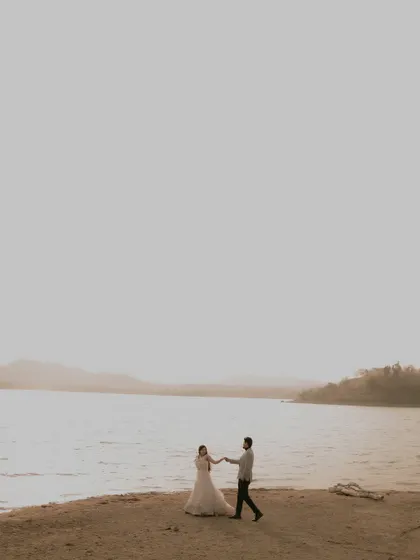 A minimalist composition of the couple against the vastness of the water, creating a feeling of serene romance.