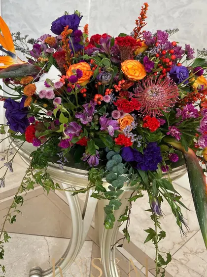 A riot of an arrangement for the discerning lover of bold color. I drizzled this piece with Dutch berries and highlighted it with African Pincushion, Lisianthus, and Rose in an out-of-the-box combination of oranges, purples, and reds.