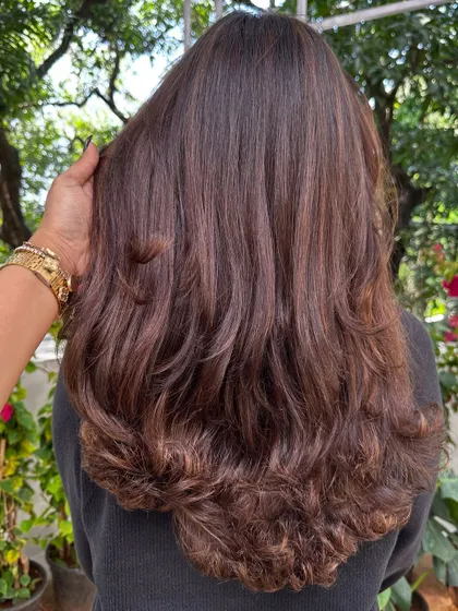 The back view of a fresh layered cut, styled with a bouncy blowout. You can see how the layers add shape and remove weight, creating a beautiful cascade effect.