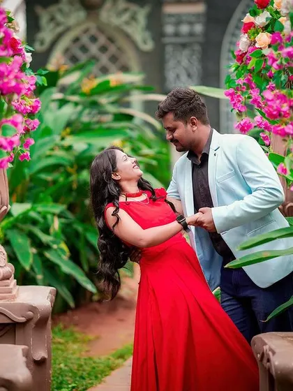A dynamic pose with the groom dipping the bride, surrounded by flowers and greenery.