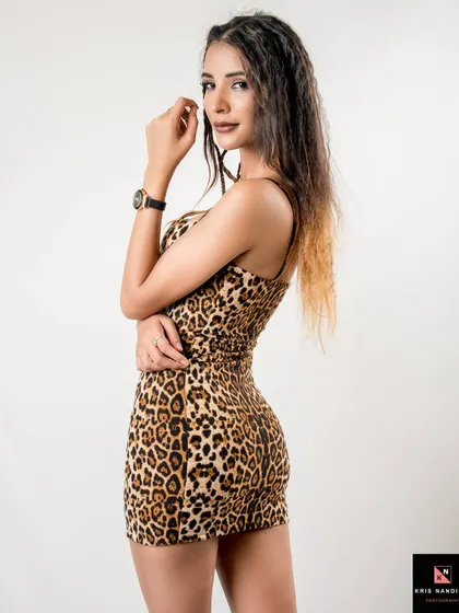 A classic fashion pose from 'The Leopardess' shoot. The model looks over her shoulder, showcasing the form-fitting dress and her wild, untamed energy.