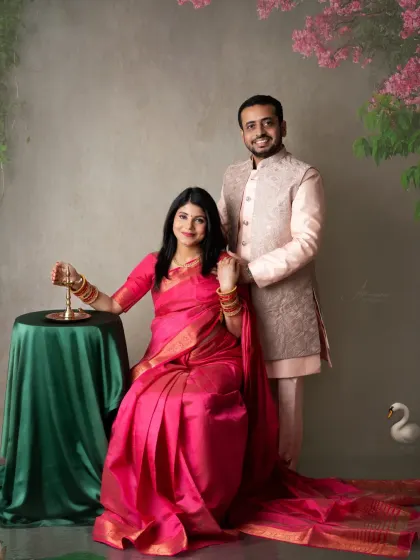 A formal couple's portrait in traditional attire. The coordinated outfits and the classic studio setup create a sophisticated and culturally rich photograph.