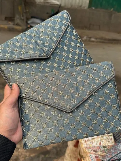 A pair of elegant envelope-style clutches with a quilted gold embroidery pattern. These are perfect for a formal dinner or event.