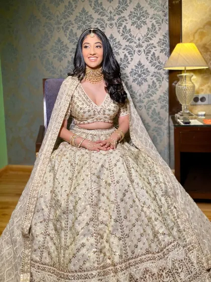 The full view of this stunning, modern bridal ensemble. The neutral, glowing makeup ensures the focus remains on the bride's radiant happiness and exquisite outfit.