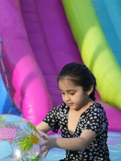 A young guest plays with a beach ball in our splash pool. We provide a variety of water toys to make our pool parties even more fun and interactive.